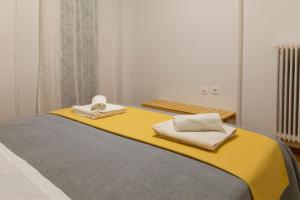 una camera da letto con un letto giallo e asciugamani di Lovely Apartment In Central Athens ad Atene