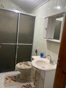 a bathroom with a shower and a toilet and a sink at Descanso Vista Alegre in Campos do Jordão