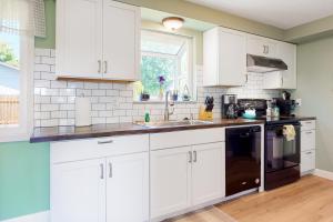 una cocina con armarios blancos y fregadero en Casa Dundee en Dundee