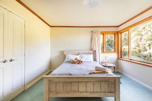 a bedroom with a bed with a teddy bear laying on it at Sea views from holiday home in Lower Hutt