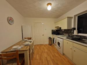 a kitchen with a table and a stove top oven at Swanley Guest House in Kent
