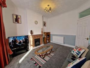 sala de estar con TV y chimenea en Swanley Guest House en Kent