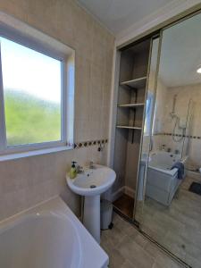 y baño con bañera, lavamanos y ducha. en Swanley Guest House en Kent