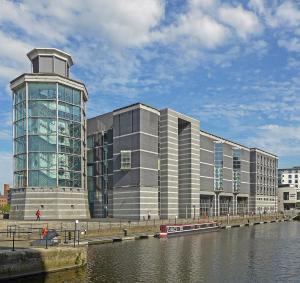 un gran edificio junto a una masa de agua en Sugarhill Leeds docks en Leeds