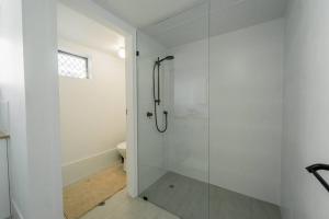 a bathroom with a shower with a glass door at Quiet Family Apartment Near Beach with Pool in Gold Coast