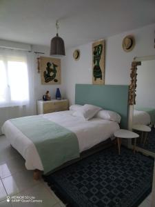 een slaapkamer met een groot bed en een tafel bij Majopau in Boujan-sur-Libron