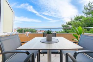 a table and chairs on a balcony with a view of the ocean at Apartmani Eterović in Baška Voda