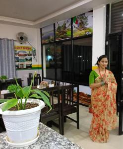 a woman standing in a room with a plant at Hotel Kanthak in Lumbini