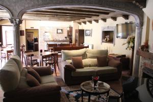 Hotel rural Monasterio de Ara Mada في Santa Colomba de las Arrimadas: غرفة معيشة مع كنب وغرفة طعام