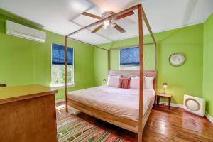 1 dormitorio con paredes verdes y cama con dosel en Rosewood Retreat, en San Antonio