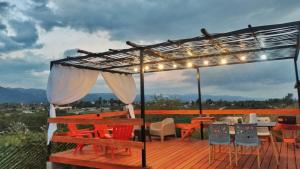 a deck with a pergola and tables and chairs at Tierras de Shiva in Valle Hermoso