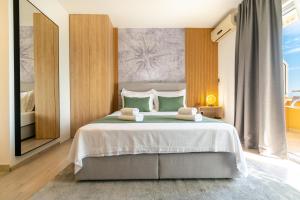 a bedroom with a large bed with two towels at Apartmani Eterović in Baška Voda