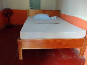 1 cama con marco de madera en una habitación en Casa apartamento palmeras, en Balgue