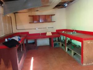 een keuken met rode werkbladen en een wastafel in een kamer bij Casa apartamento palmeras in Balgue