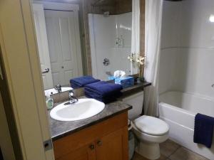 La salle de bains est pourvue d'un lavabo, de toilettes et d'une baignoire. dans l'établissement Ocean View Townhome - Sooke Harbour Marina, à Sooke