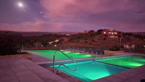 una piscina por la noche con una casa en el fondo en LA TOSCANA casas y suites en Nono