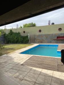 a swimming pool in a yard with a brick wall at Villa Licciana in San Juan