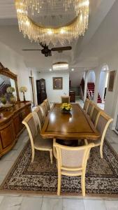 uma sala de jantar com uma mesa e cadeiras e um lustre em Spacious Home in Kuala Terengganu em Kuala Terengganu