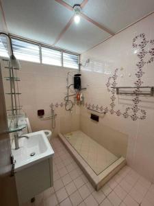 a bathroom with a sink and a shower and a toilet at Spacious Home in Kuala Terengganu in Kuala Terengganu