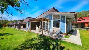 una pequeña casa azul con patio y césped en El Cielo by Villa Alejandro, en Boquete