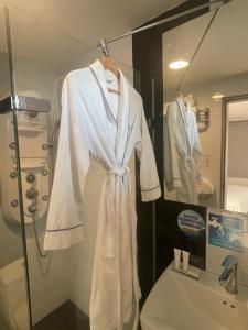 a bathroom with a robe hanging in a shower at Hotel Juan Pablo 2 in Ríohacha