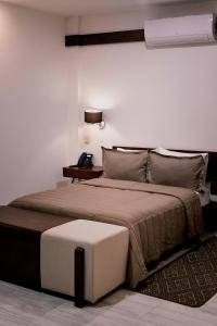 a bedroom with a large bed with a white wall at Hotel Casa Cantera in Oaxaca City