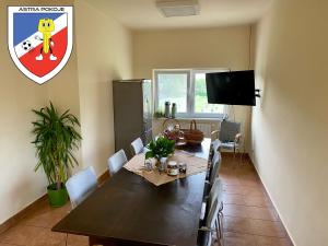 une salle à manger avec une table et une télévision dans l'établissement Pokoje Astra, à Spytkowice
