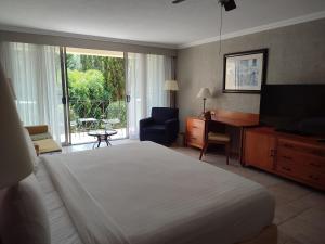 a hotel room with a bed and a desk and a television at Ixtapan de la Sal Marriott Hotel & Spa in Ixtapan de la Sal