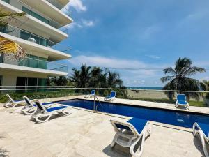 uma piscina com espreguiçadeiras ao lado de um edifício em MORROS EPIC 1111 em Cartagena de Indias