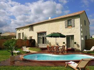 a house with a swimming pool in front of a house at Villa with covered terrace in rural Chalais in Chalais