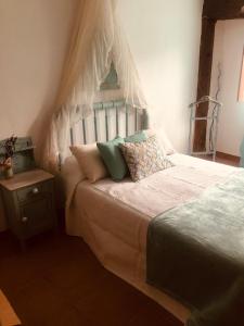 a bedroom with a bed with a canopy and pillows at Las maletas del pasiego in Quintana