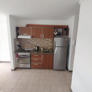 a kitchen with wooden cabinets and stainless steel appliances at Depto del Arroyo in San Martín de los Andes