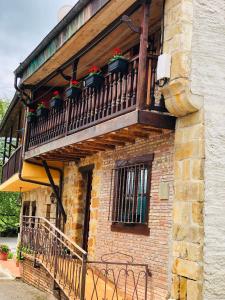 a balcony with potted plants on a brick building at Las maletas del pasiego in Quintana