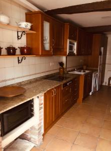a kitchen with wooden cabinets and a counter top at Las maletas del pasiego in Quintana +40 photos