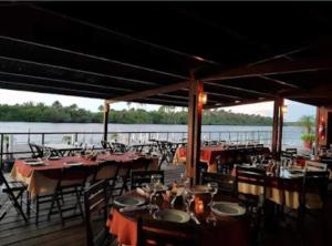 a restaurant with tables and chairs on a dock at Barreirinhas Gran Lençóis Flat Residence Mandacaru 506 Particular in Barreirinhas