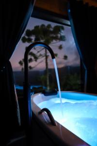 a bath tub with a water fountain in it at Infinity Valley Cabanas in Urubici