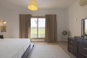 um quarto com uma cama e uma grande janela em Safty Palm Oasis Private Pool & Beach Access em Ain Sokhna