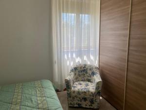 Villa Mima في سانتيرامو إن كولي: غرفة نوم مع كرسي بجوار نافذة