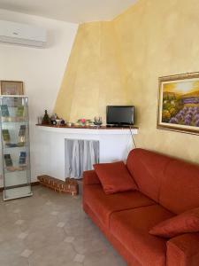 Villa Mima في سانتيرامو إن كولي: غرفة معيشة بها أريكة حمراء و لوحة