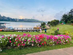 a group of flowers in a park next to a body of water at Breeze Holiday Casa in Nuwara Eliya