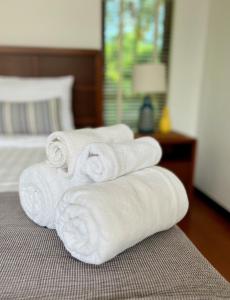 a pile of towels sitting on top of a bed at Tropical villa within 5 minutes walk to Bangtao Beach in Bang Tao Beach