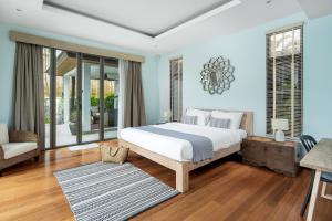 a bedroom with a large bed and a living room at Tropical villa within 5 minutes walk to Bangtao Beach in Bang Tao Beach