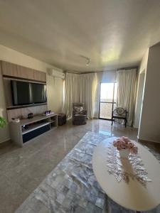 sala de estar amplia con mesa y TV en Apartamento no Centro Foz do Iguaçu 130 mt, en Foz do Iguaçu