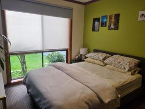 1 dormitorio con cama y ventana grande en Nava home in Rowville, en Rowville