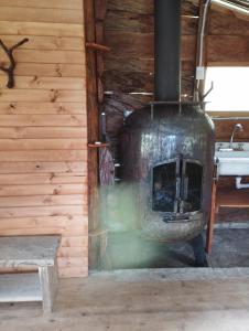 una estufa de leña en una cabaña con fregadero en CABAÑAS ALASKA, en Sesquilé