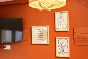 a wall with framed drawings of a woman on it at L'Atelier Terracotta in Carrières-sous-Poissy