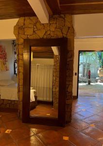 a mirror in a room with a stone wall at Locanda Samara Beach in Sámara