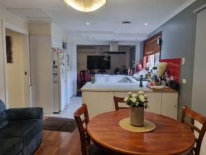 Tani Family home في Rowville: غرفة معيشة مع طاولة ومطبخ