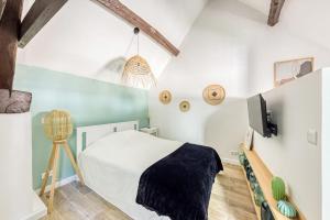 ein Schlafzimmer mit einem Bett und einem TV an der Wand in der Unterkunft Le Studio Green Lime in Carrières-sous-Poissy