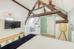 Schlafzimmer mit einem Bett und einem Flachbild-TV in der Unterkunft Le Studio Green Lime in Carrières-sous-Poissy
